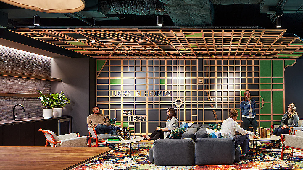 A group of people sitting on a couch in a room with a wood ceiling.