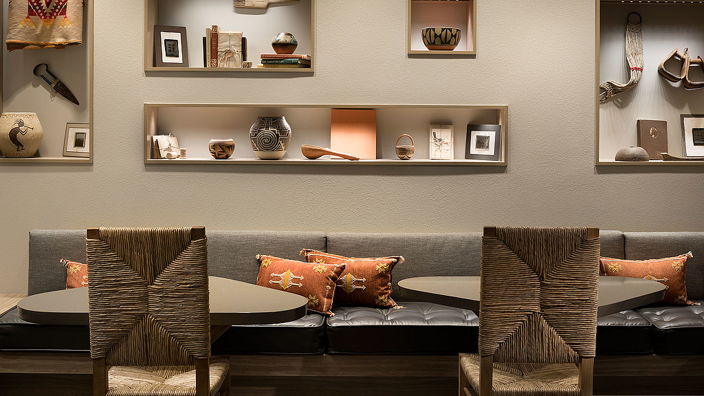 A room with a couch and chairs.