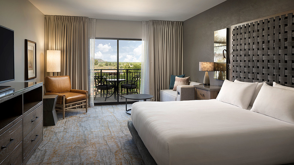 A bedroom with a large window.