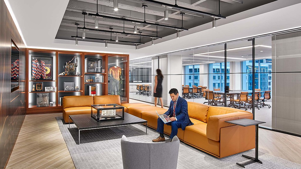 A person sitting on a couch reading a book.