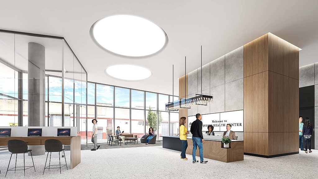 A group of people in a large room with a large glass wall.