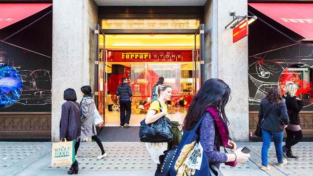 A group of people walking outside a store.