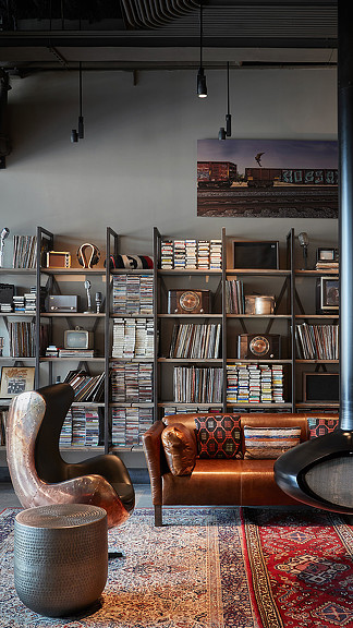 A room with a bookcase and a chair.
