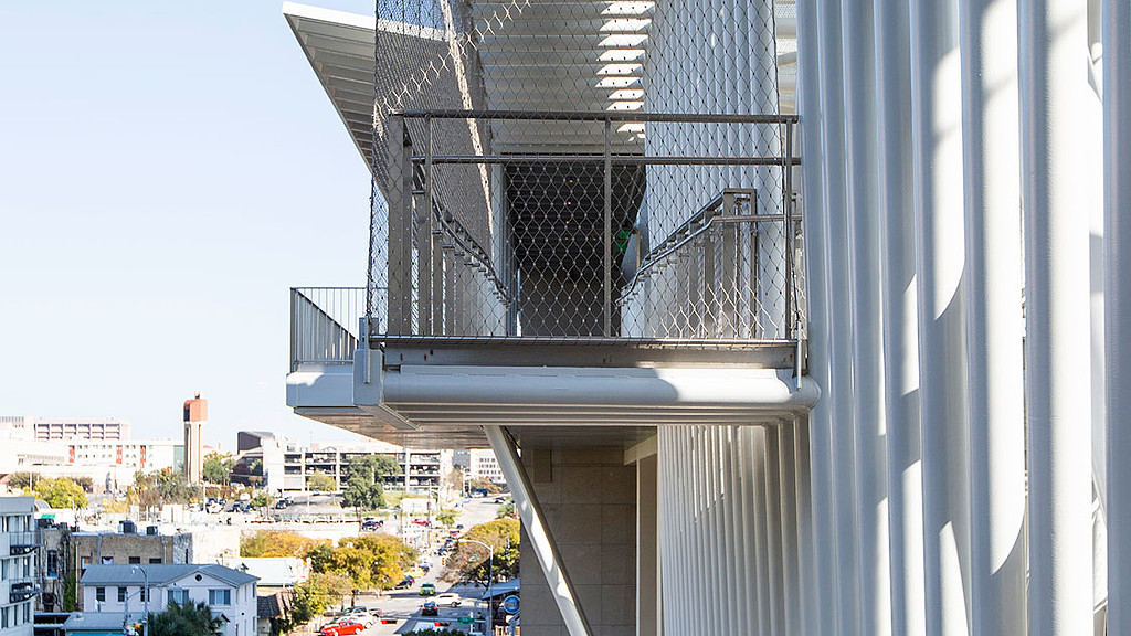 A tall building with cars parked in front of it.