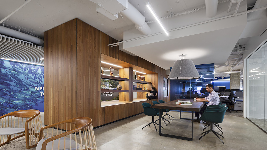 A person sitting at a table in a room with a large window.