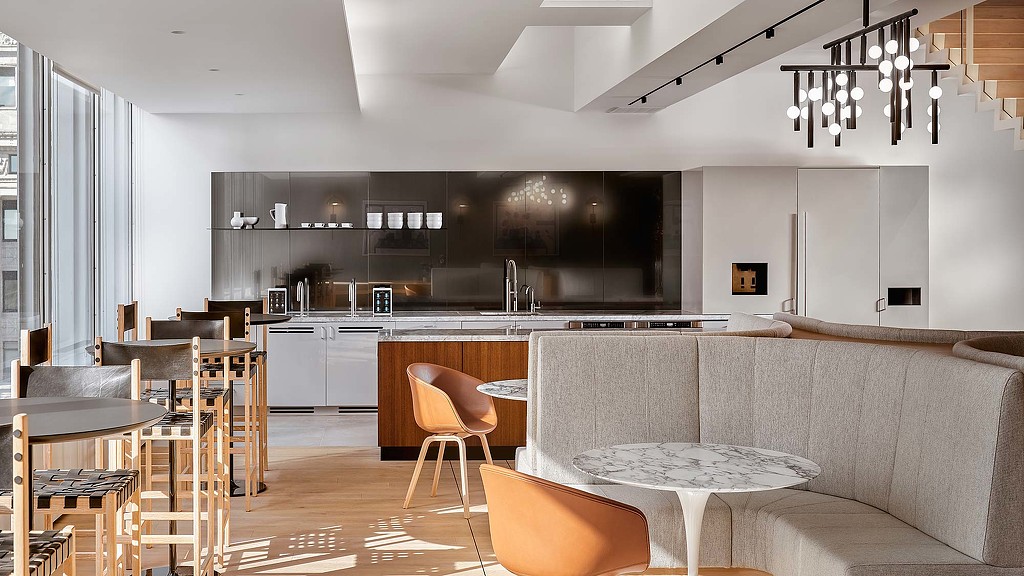 A large kitchen with a bar and chairs.