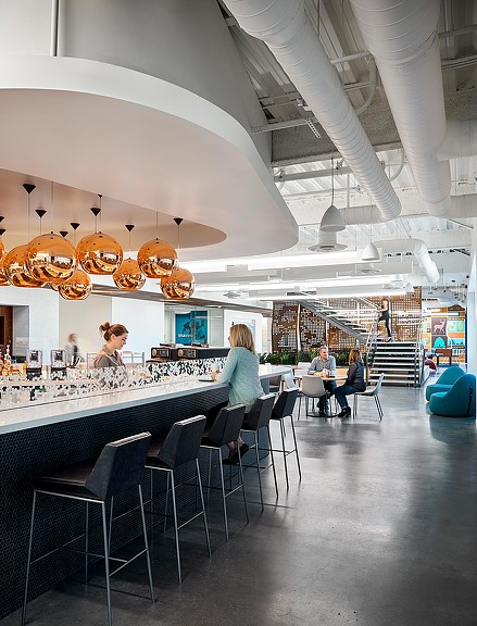 A group of people sitting at a table in a large room.