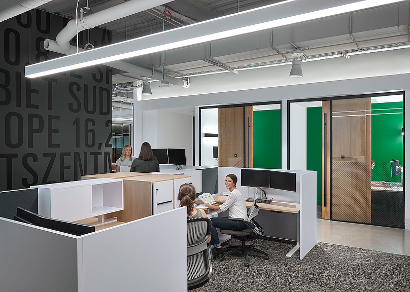A group of people sitting at a table in a room with green walls.