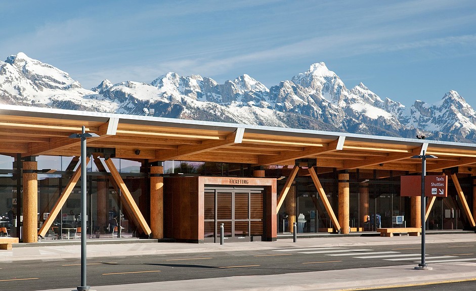 A building with snow covered mountains in the background.