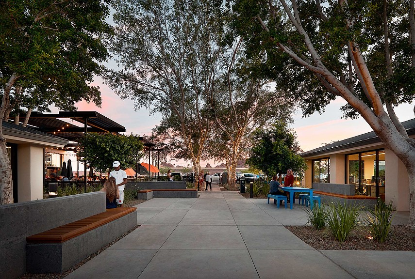 A group of people sitting on benches in a park.