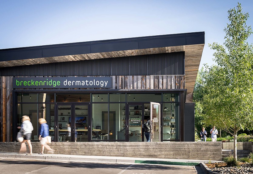 A group of people walking out of a building.