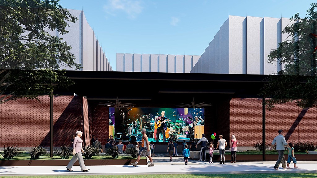 A group of people walking on a sidewalk in front of a building.