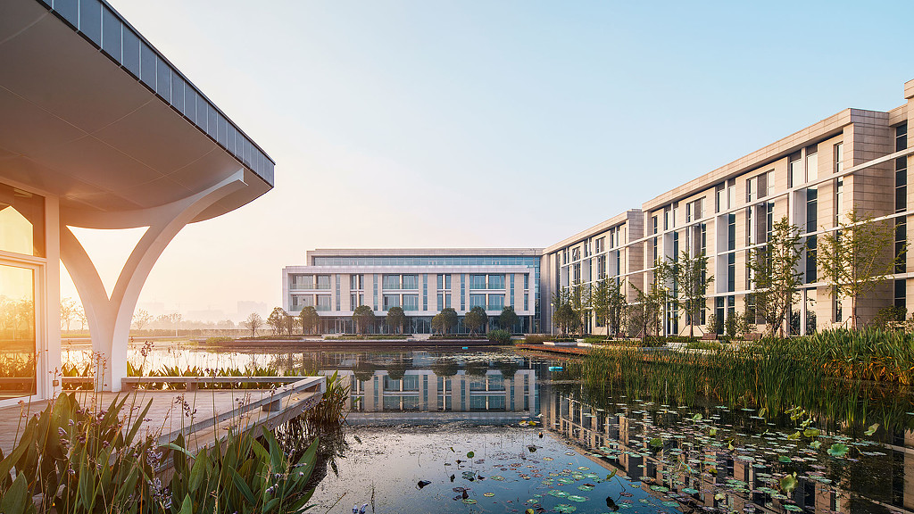 A building with a pond in front.
