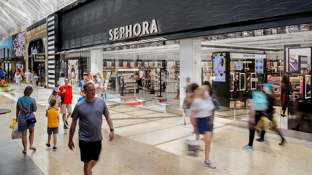 A group of people walking in a mall.