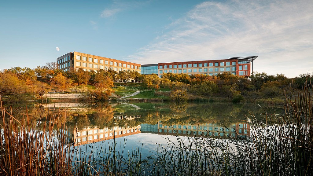 A building with a pond in front of it.