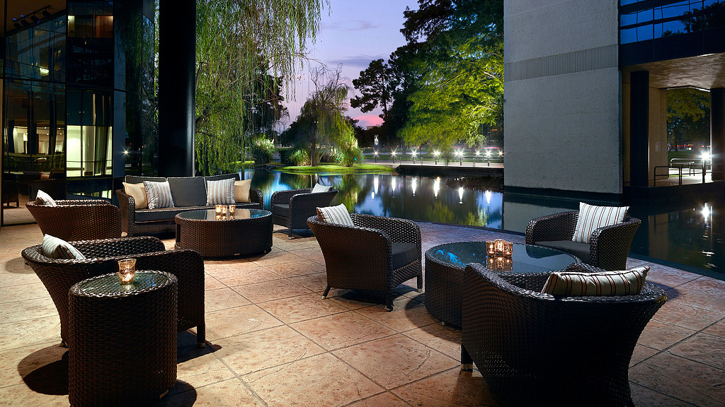 A patio with chairs and a pool.