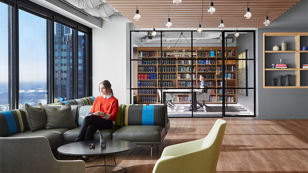 A person sitting on a couch in a library.