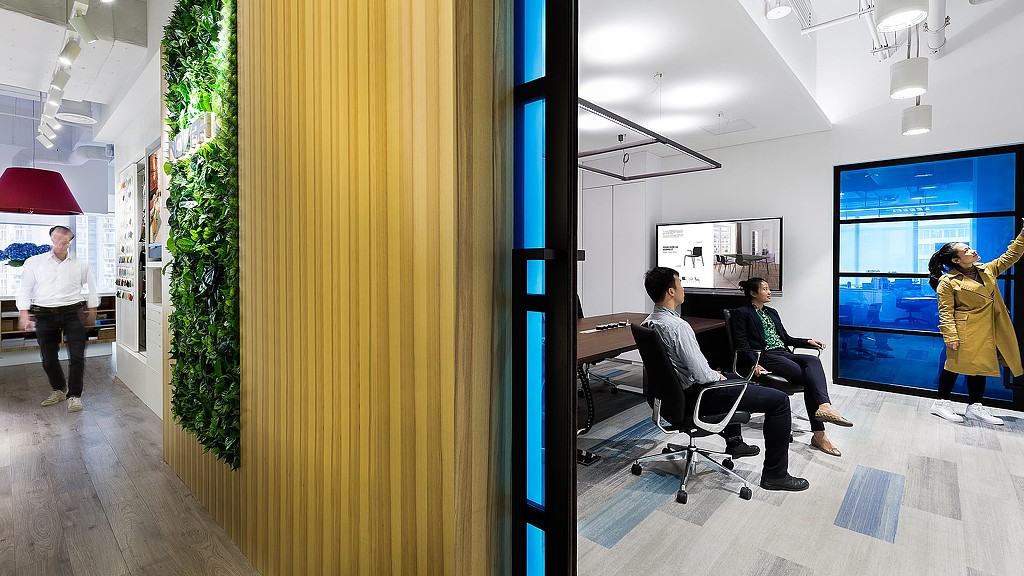 A person standing in front of a screen with a person sitting in a chair.