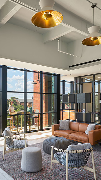 A room with a glass door and a couple of chairs and a couple of people standing in the.