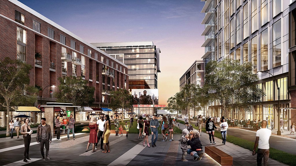 A group of people walking on a street between buildings.