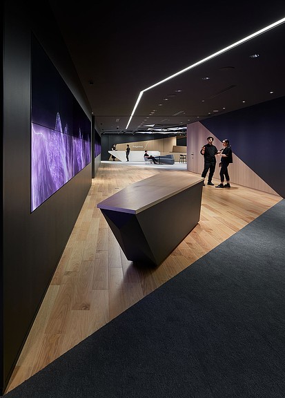 A group of people standing in a room with a large purple wall.