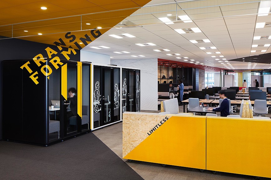 A person sitting at a desk in a computer store.