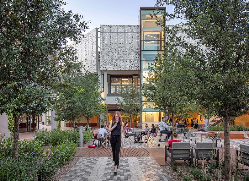 A person walking in a courtyard.