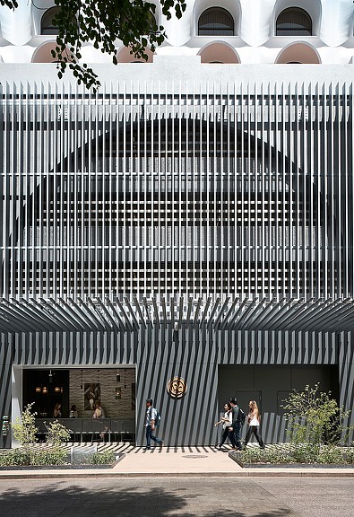 A group of people walking outside of a building.