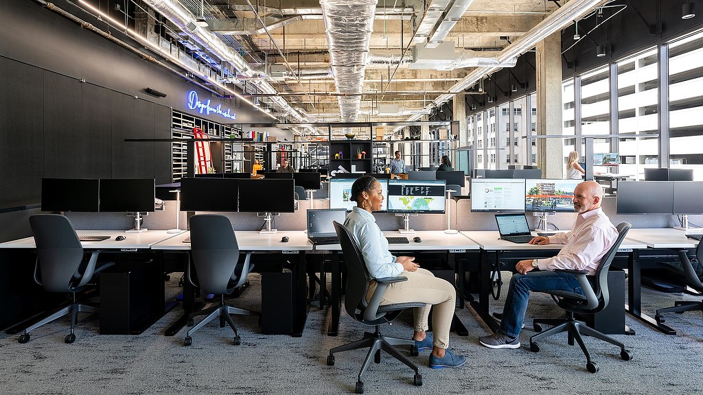 Men sitting at a table with computers.