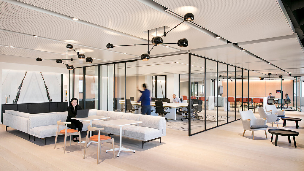 A room with white couches and people in it.