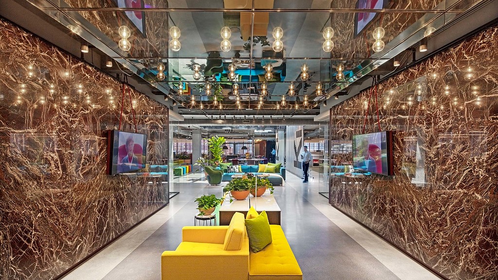 A room with a couch and a table with a plant on it.