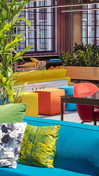 A room with a couch and chairs.