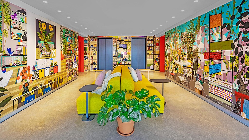 A room with a couch and a plant in it.