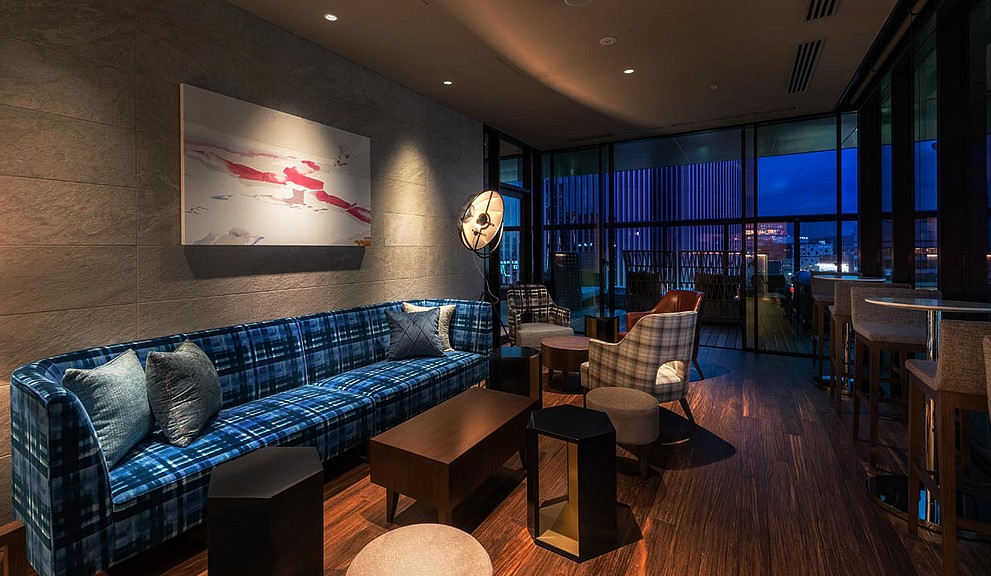 A room with a couch and chairs.