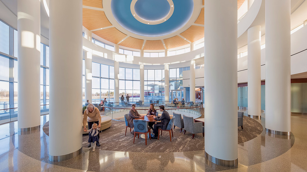 A group of people sitting at a table in a large room.