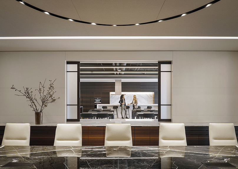 A room with a large glass wall and a large table with chairs.