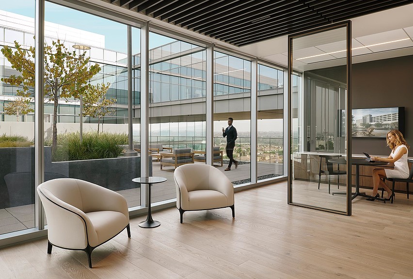 A man and woman in a room with windows and a table.