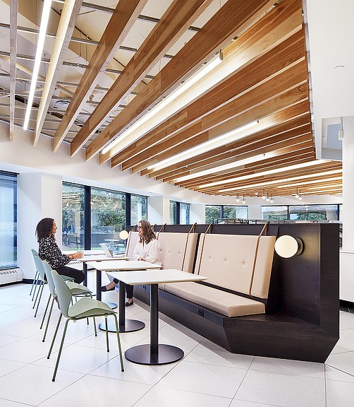 A couple of women sitting at a table in a room with a couch and a table.