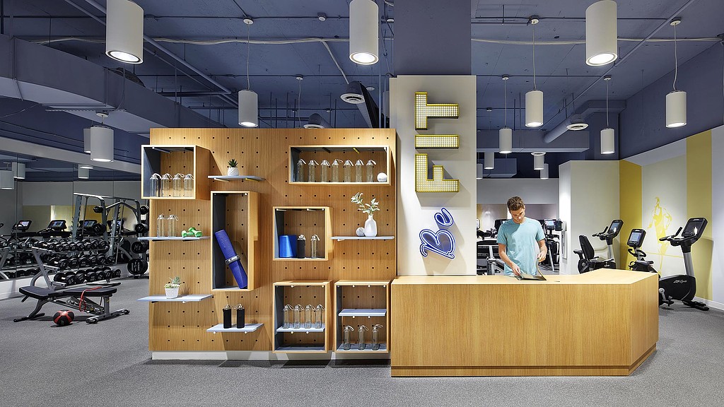 A person standing in a room with shelves and equipment.