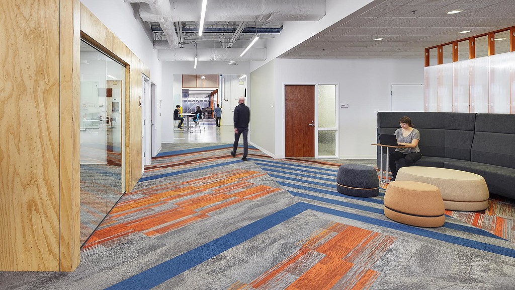 A woman sitting on a chair in a room with a man standing.