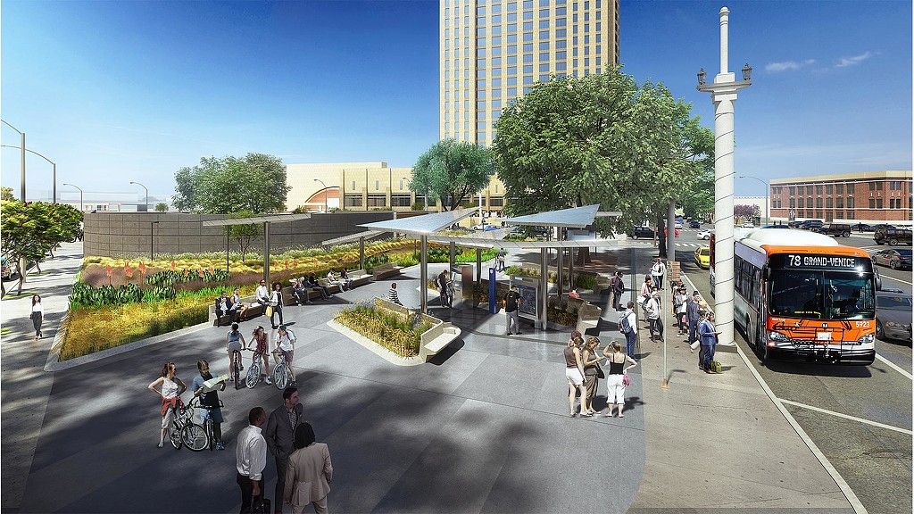 A group of people walking on a street with bikes and cars.