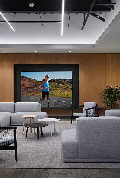 A person jumping in the air in front of a large screen.