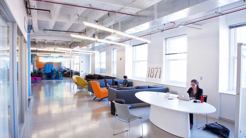 A man and woman sitting at a table in a room with a large window.