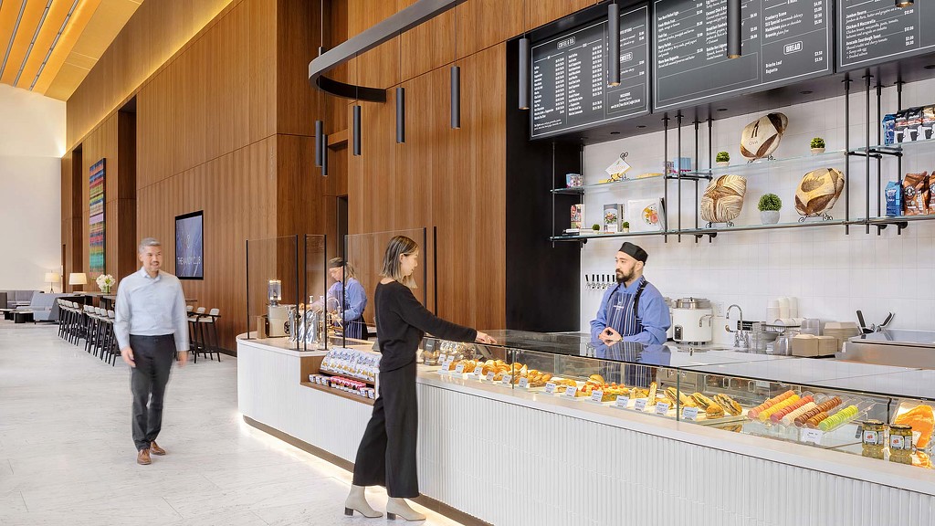 A person standing next to a counter with food on it.