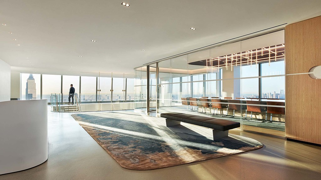 A large room with a large glass wall and a large room with a person standing in it.