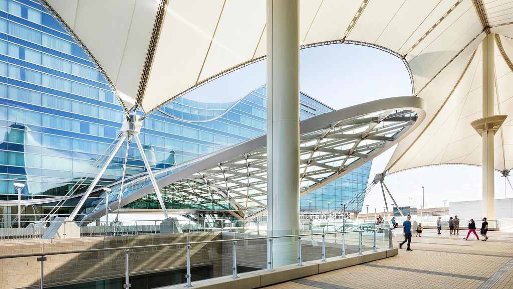A large glass building with a walkway.