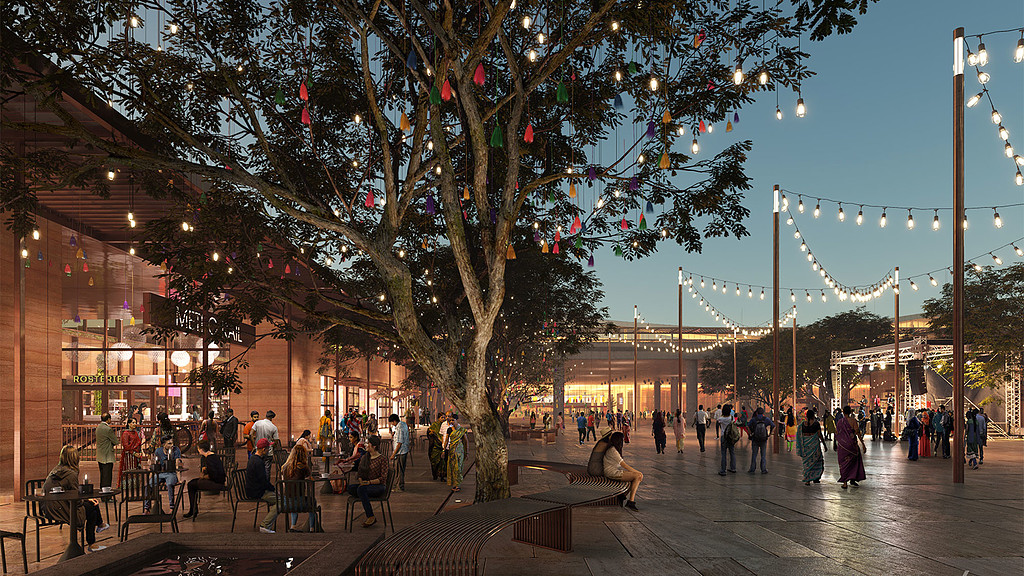 A group of people walking on a street with a tree and buildings.