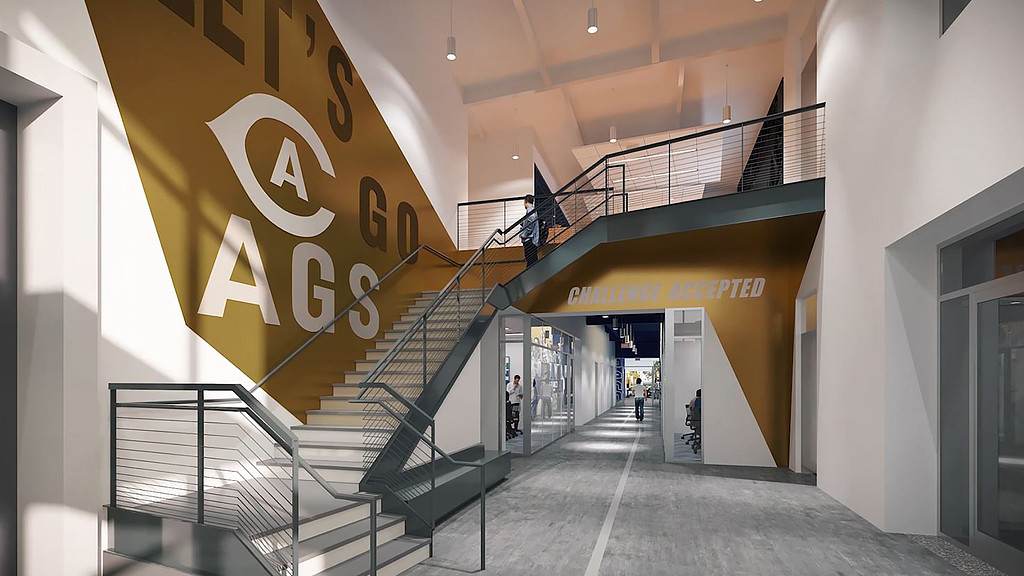 A long hallway with people walking up the stairs.