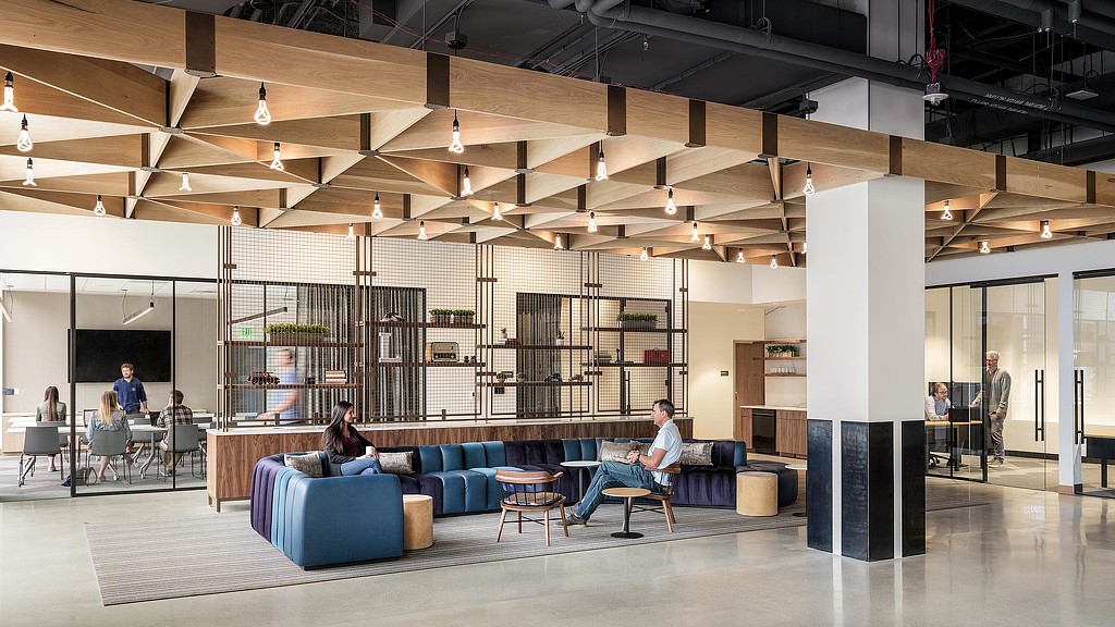 A man and woman sitting on a couch in a library.