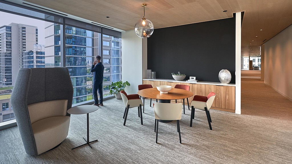 A person standing in a room with a table and chairs.